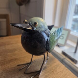 Fågel med blå/gröna vingar i hamrad plåt